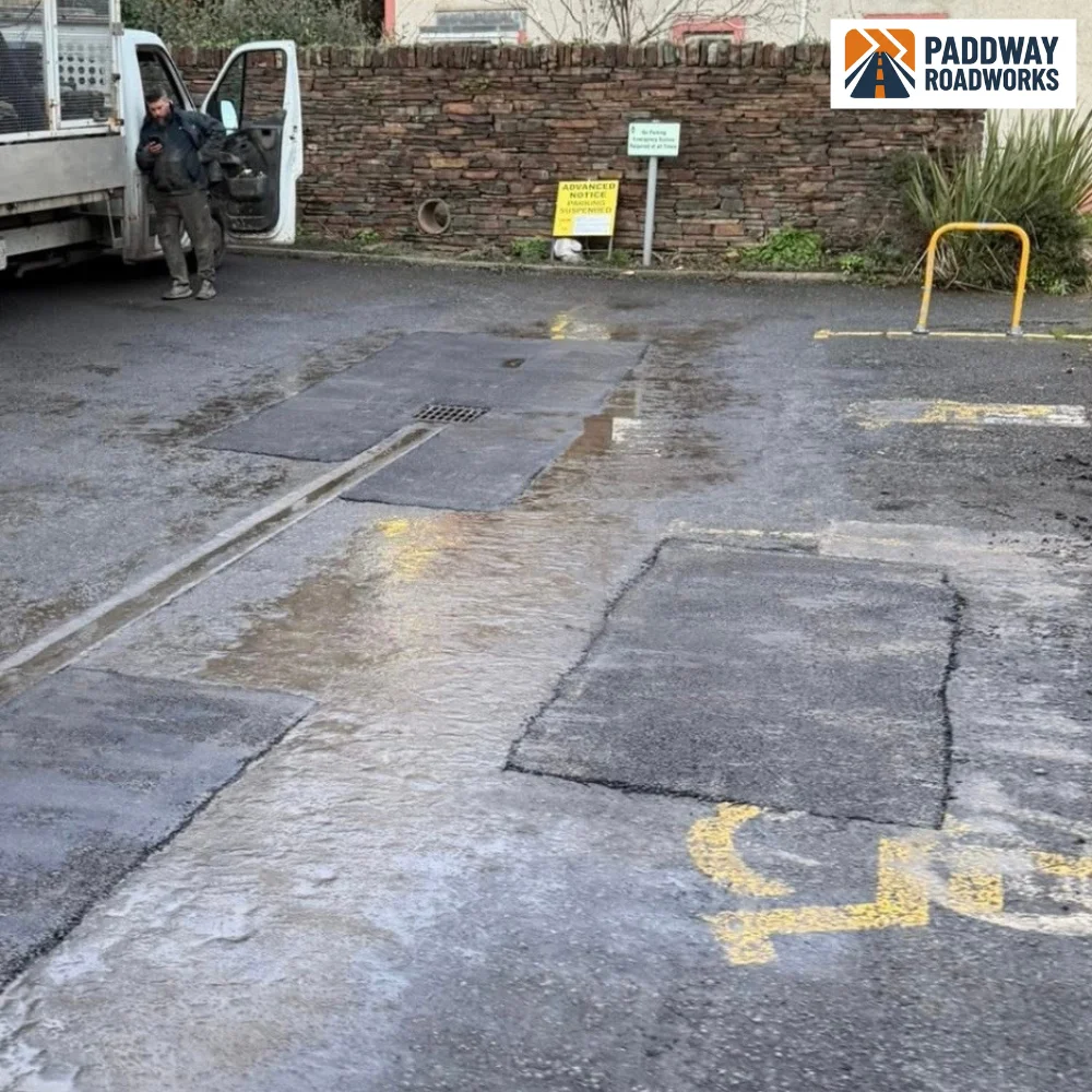 Failed tarmac and potholes in a parking bay ready to be cut out and repaired