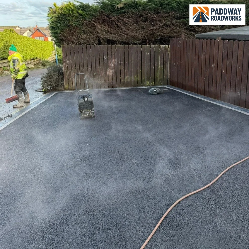 Fresh tarmac being rolled and compacted on a new driveway by Paddway Surfacing Solutions