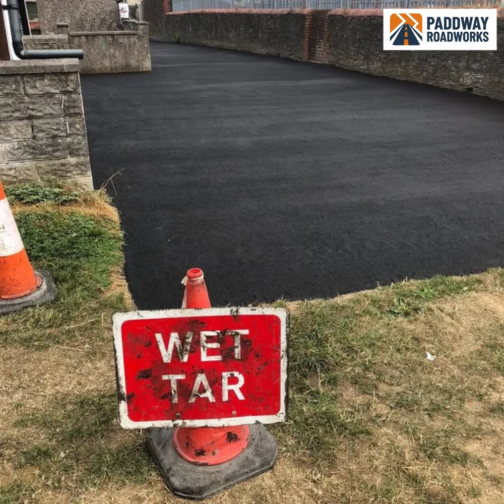 Newly laid tarmac driveway with a wet tar safety sign in place
